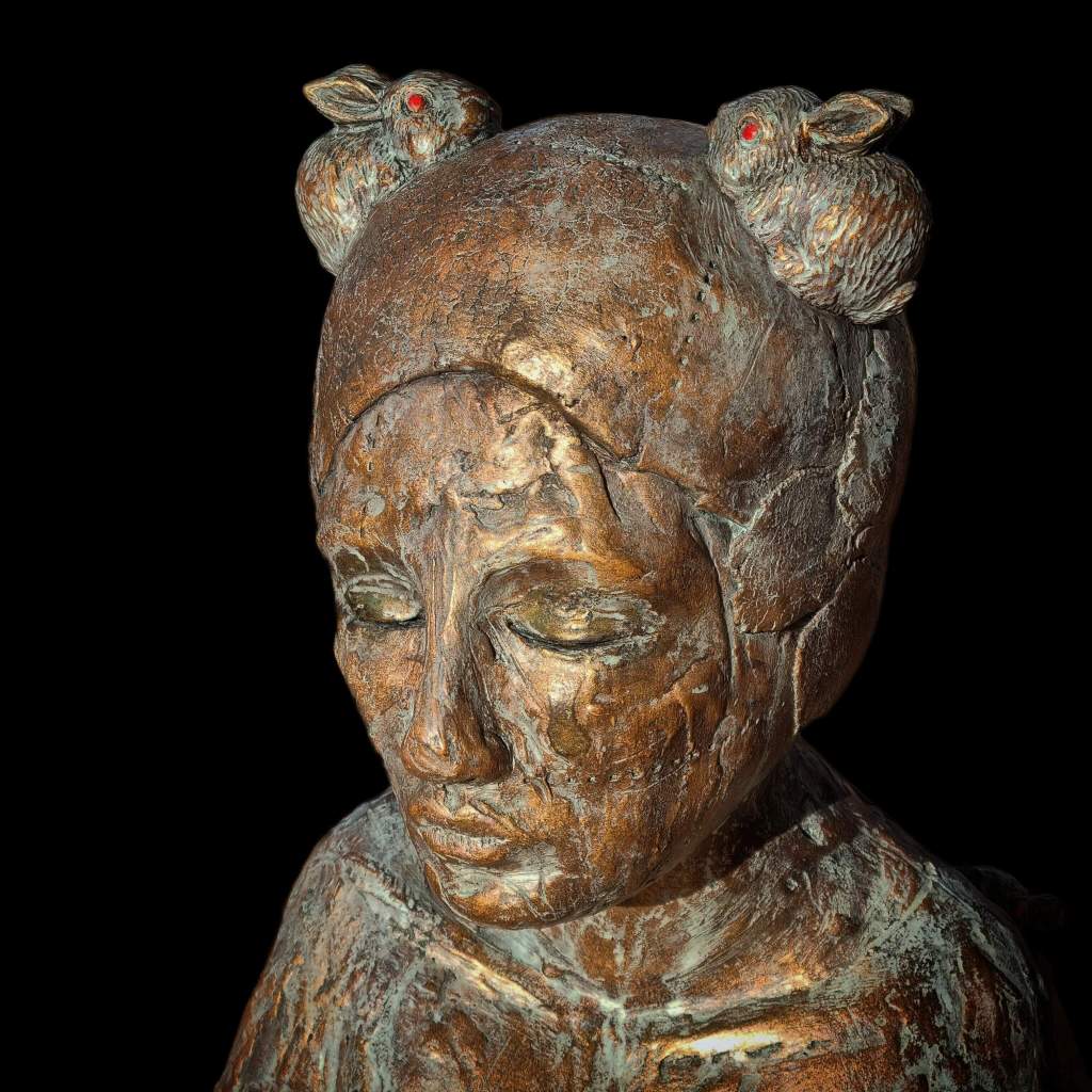 Girl with eyes closed bronze ceramic statue with rabbits for ears on black background
