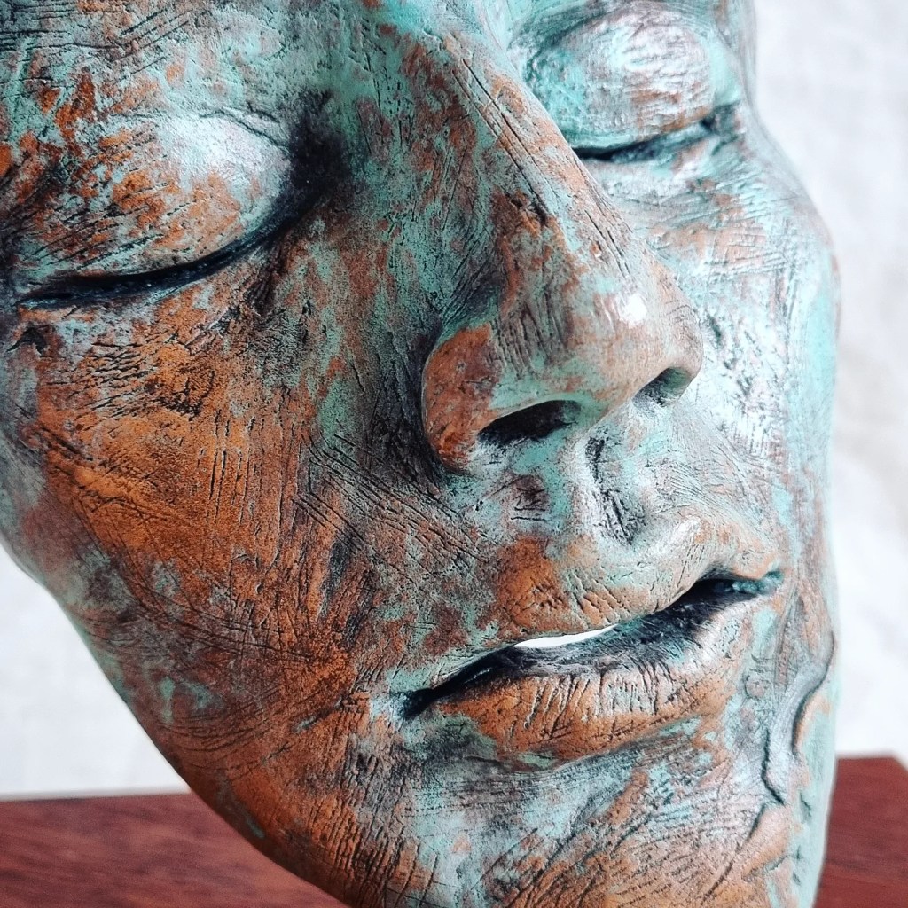 Abstract sleeping face ceramic sculpture with blue and brown textures