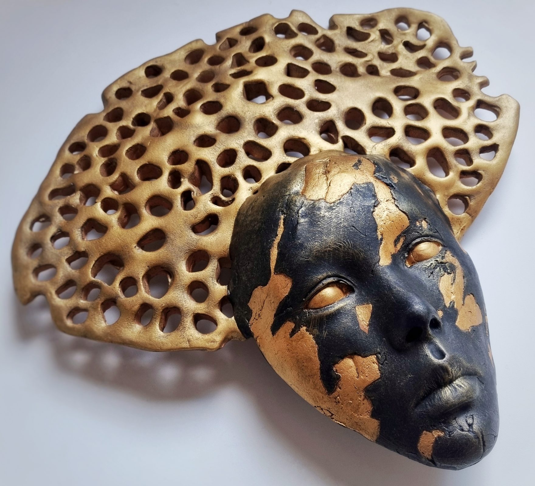 Gold and black surreal wall art with holes headpiece. Karen Wilde New Zealand Contemporary Ceramic Sculpture Artist