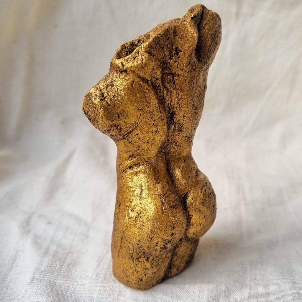 Back view of gold female nude sculpture